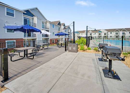 A sunny day at the outdoor grilling area with seating at Chase Creek Apartment Homes, Huntsville, AL, 35811