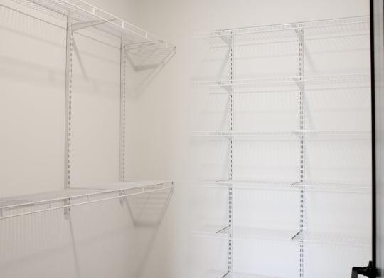a walk in closet with white shelving and white walls  at Avant & Avant II, Carmel, 46032