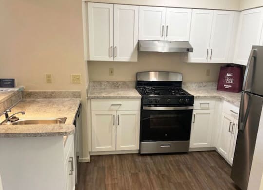 a renovated two bedroom two bath kitchen with white cabinets at Canal Club Apartments, Lansing, MI