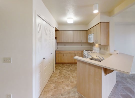 a kitchen with wooden cabinets and white appliances at Colonial Pointe at Fairview Apartments, Bellevue, NE
