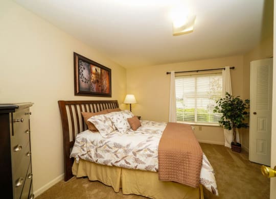 a bedroom with a window and walk-in closet at Colonial Pointe at Fairview Apartments, Bellevue, NE
