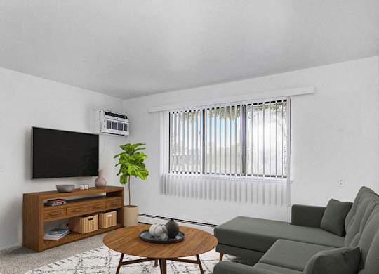 A garden style living room with a grey couch, a coffee table, and a television at Concord Place Apartments in Kalamazoo, Michigan 49009