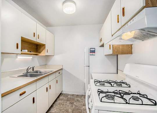 A kitchen with a white stove and sink at Concord Place Apartments, Kalamazoo, MI
