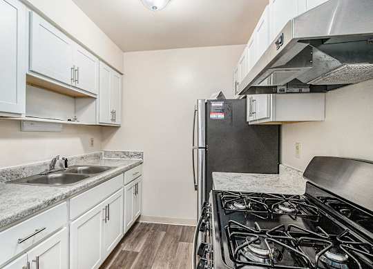 A kitchen with a stainless steel refrigerator and gas stove at Concord Place Apartments, Kalamazoo, MI