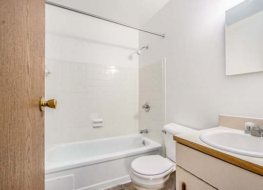 A bathroom with a toilet, bathtub and vanity area at Concord Place Apartments, Kalamazoo, MI