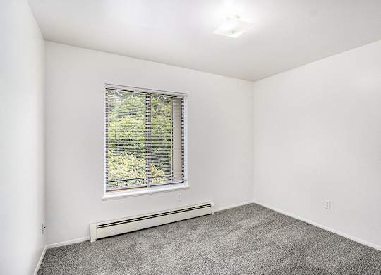 A bedroom with a large window at Concord Place Apartments, Kalamazoo, MI