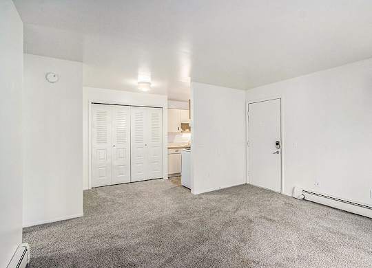 A large living and dining room with a carpeted floor at Concord Place Apartments, Kalamazoo, MI