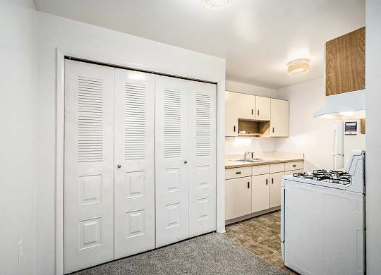 A kitchen with white appliances and wooden cabinets at Concord Place Apartments, Kalamazoo, MI
