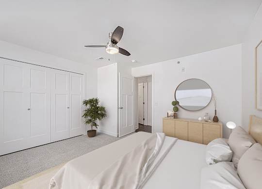 A bedroom with a bed, dresser, mirror, and a ceiling fan at Copper Creek Apartment Homes, Maize, Kansas
