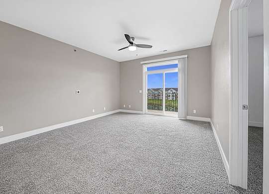 A living room with a 9' ceiling and a ceiling fan an empty bedroom with a ceiling fan and ensuite at Copper Creek Apartment Homes, Kansas, 67101
