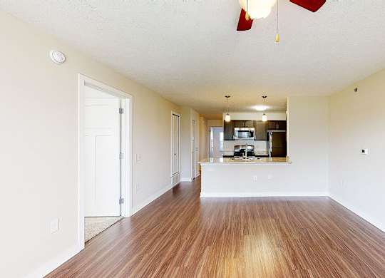A long, empty living room with hard-surface floors  at Copper Creek Apartment Homes, Maize, Kansas