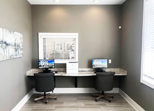 Dual workspace with monitors and office chairs at Copper Creek Homes Apartments, Kansas