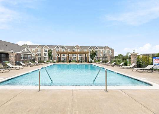 Resort style pool with lounge chairs and pergola at Copper Creek Homes Apartments, Kansas, 67101
