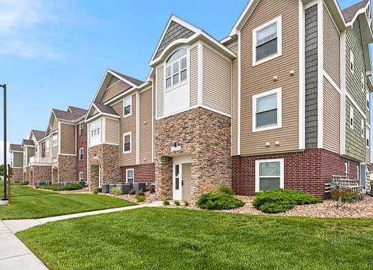 Multi level apartment building with brick and stone accents at Copper Creek Homes Apartments, Kansas