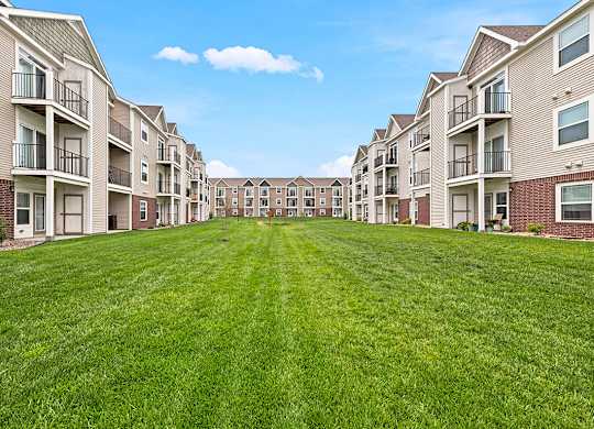 Courtyard lawn between multi story residential buildings at Copper Creek Homes Apartments, Kansas, 67101