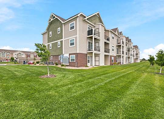 Apartment buildings with balconies and landscaped lawn at Copper Creek Homes Apartments, Maize, KS