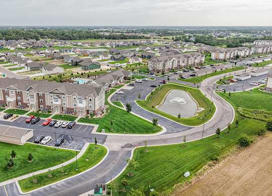 Aerial view of residential community with retention pond at Copper Creek Homes Apartments, Kansas, 67101