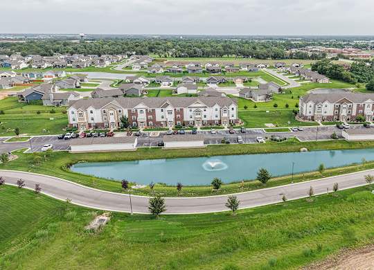 Aerial view of residential neighborhood with retention pond at Copper Creek Homes Apartments, Maize, KS 67101