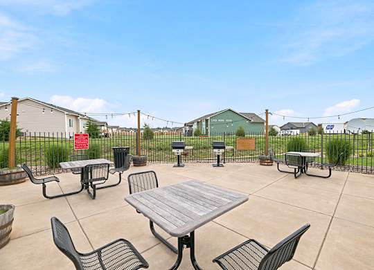 Outdoor barbecue patio with grills and picnic tables at Copper Creek Homes Apartments, Maize, 67101
