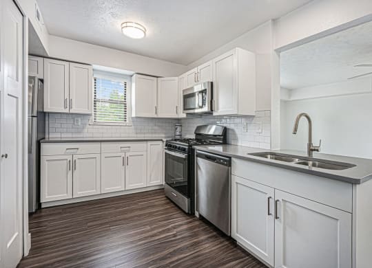 end kitchen with white cabinets and stainless steel appliances at The Crossings Apartments, Michigan, 49508