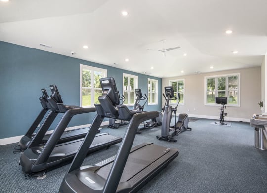 gym has plenty of cardio equipment and windows at The Crossings Apartments, Michigan, 49508