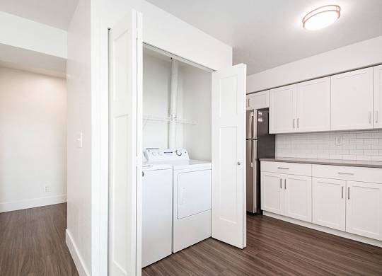 A white laundry room with a washer and dryer at The Crossings Apartments, Grand Rapids, MI, 49508