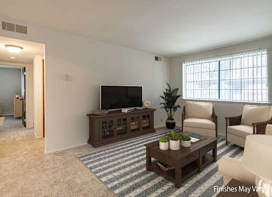 A living room with a television, chairs, and a coffee table at Beacon Hill and Great Oaks Apartments, Rockford, Illinois