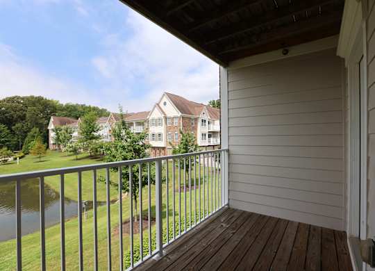 A balcony with a view of a lake and houses.