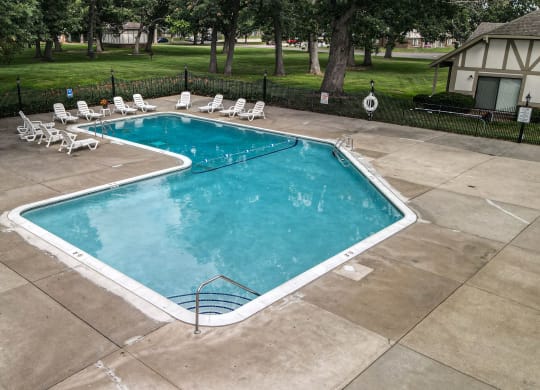 a swimming pool with chaise lounge chairs and trees in the background at Beacon Hill and Great Oaks Apartments, Illinois, 61109