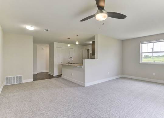 A spacious living and dining room with a ceiling fan and a window at Dodson Pointe Apartment Homes, Rogers, AR
