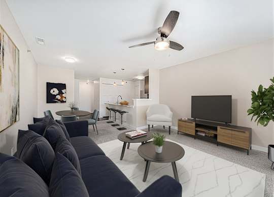 A living room with a dark blue sofa and a ceiling fan at Dodson Pointe Apartment Homes, Rogers