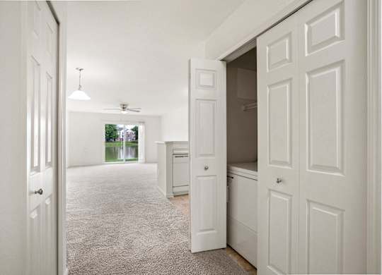 A white hallway with a carpeted floor and white walls at Towne Lakes Apartments, Grand Chute