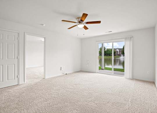 A room with a ceiling fan and carpeted floor at Towne Lakes Apartments, Grand Chute