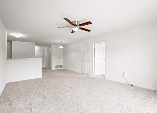 A room with a ceiling fan and carpeted floor at Towne Lakes Apartments, Grand Chute