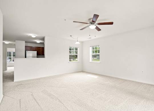 A room with a ceiling fan and carpeted floor at Towne Lakes Apartments, Grand Chute