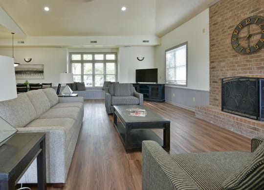 a living room with couches and a fireplace and a television at Heatherwood Apartments, Grand Blanc
