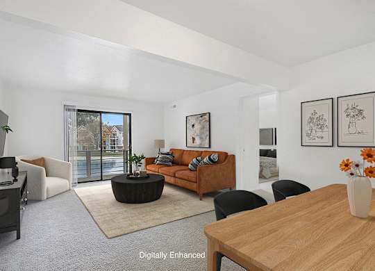 A living room with a brown sofa and a wooden table at Dupont Lakes Apartments in Fort Wayne, IN