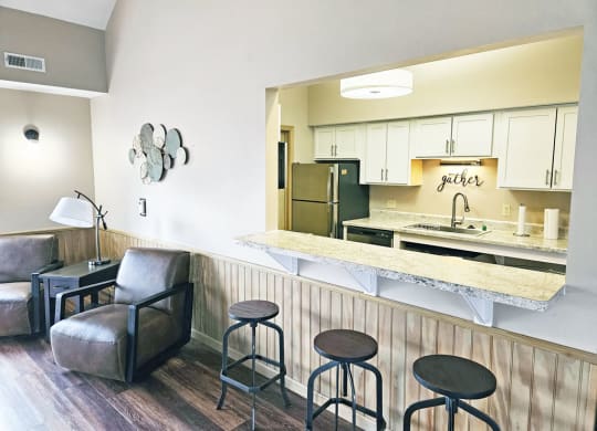 Clubhouse kitchen with a bar and stools at Dupont Lakes Apartments in Fort Wayne, IN 46825