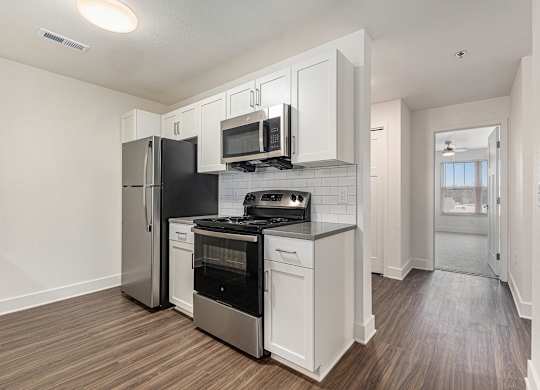 A kitchen with white cabinets and a hard surface flooring Spacious bedroom with large windows and walk in closet at Eagle Ridge Apartment Homes,  Michigan 49685