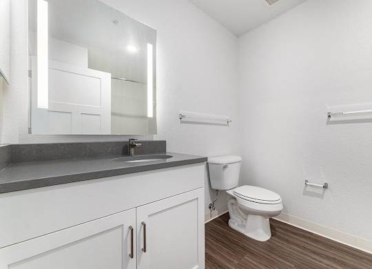 A white toilet sits next to a sink in a bathroom at Eagle Ridge Apartment Homes, Traverse City, Michigan