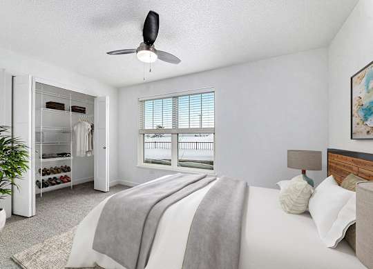 A bedroom with a large bed and a walk in closet with organizers at Eagle Ridge Apartment Homes, Traverse City, MI 49685