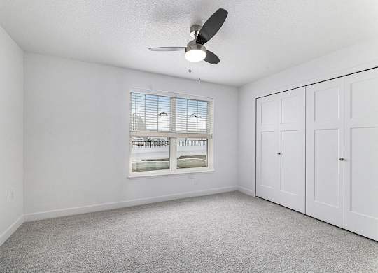 A bedroom with a ceiling fan and a window at Eagle Ridge Apartment Homes, Traverse City, Michigan