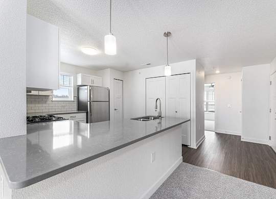 A modern kitchen with white cabinets and a grey countertop at Eagle Ridge Apartment Homes, Traverse City, Michigan