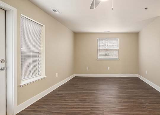 An enlarged living room with hard surface flooring and a window with blinds at Eagle Ridge Apartment Homes, Traverse City, MI 49685
