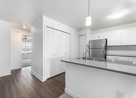 A kitchen with white cabinets and a stainless steel refrigerator at Eagle Ridge Apartment Homes, Traverse City, Michigan