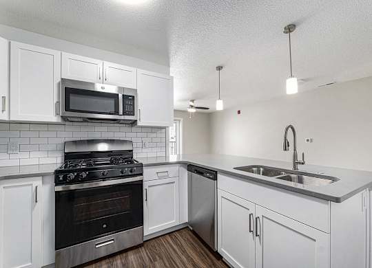 A kitchen with a stove, oven, microwave, and sink at Eagle Ridge Apartment Homes, Traverse City, Michigan