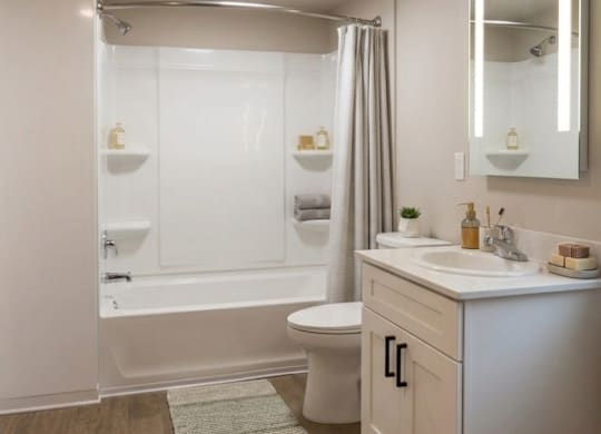 A white bathroom with a toilet, sink, and bathtub.