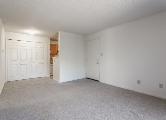an empty living area with a kitchen in the background at Bavarian Village Apartments, Indiana, 46235