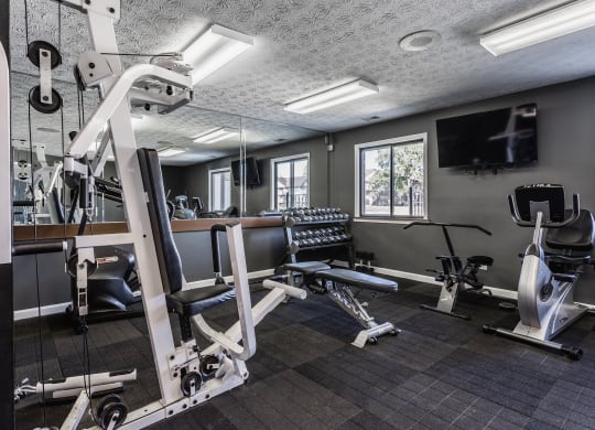 a gym with exercise equipment and a flat screen tv at Bavarian Village Apartments, Indianapolis