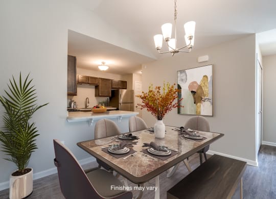 a dining room with a table and chairs and a kitchen  at Killian Lakes Apartments and Townhomes, South Carolina
